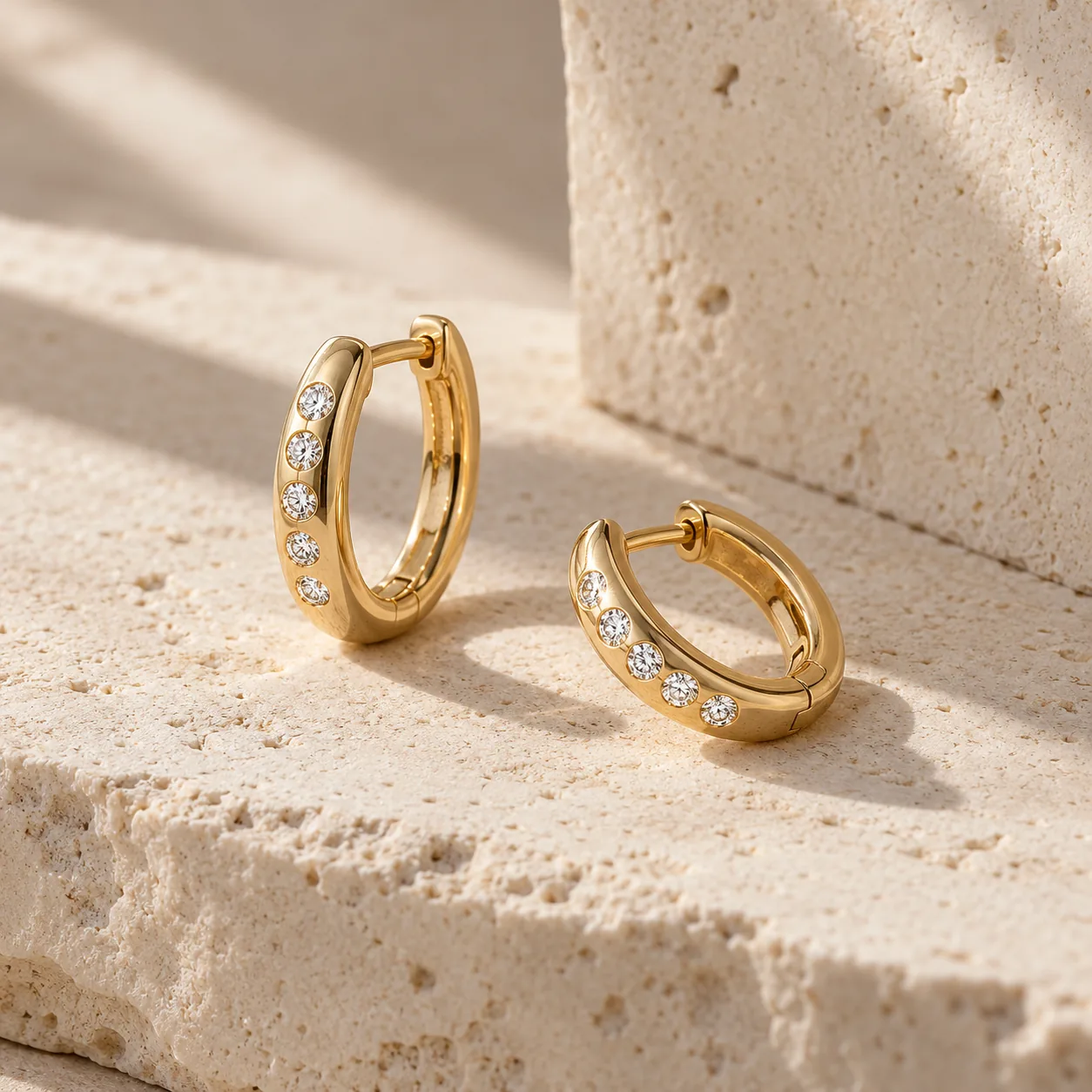 Pair of gold hoop earrings with a short line of small white diamonds