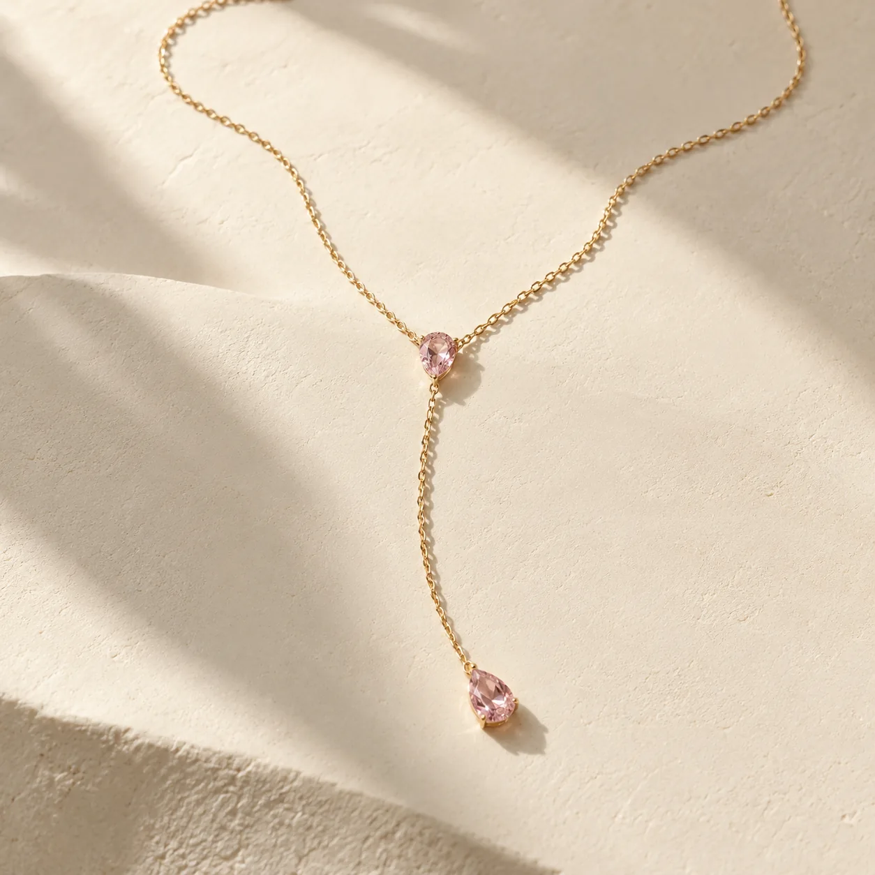 Gold Y-shaped lariat necklace with two pear shaped pink sapphires